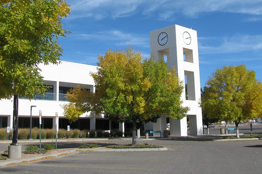 western view of the san juan college educational services building with the clocktower in the forefront, trees changing colors to yellow and gold.